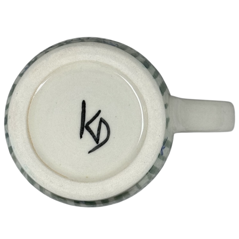 Bottom view of Karen Donleavy Bichon Frise mug showing artist KD signature on ceramic base and handle