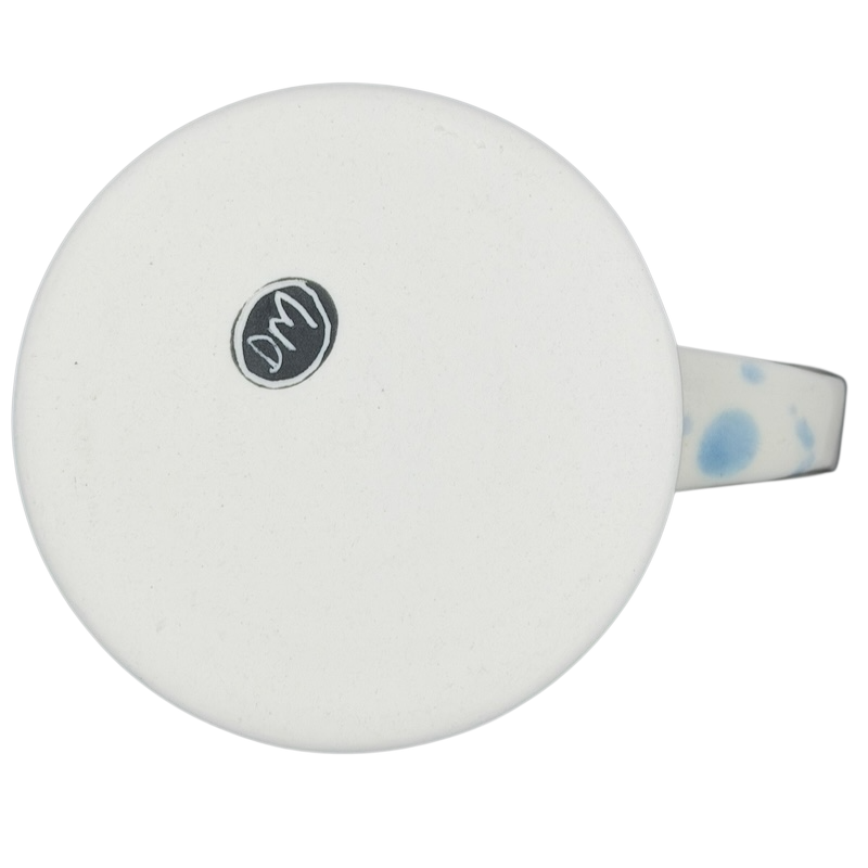 Bottom view of a narwhal signed pottery mug showcasing a smooth white glaze and a decorative handle