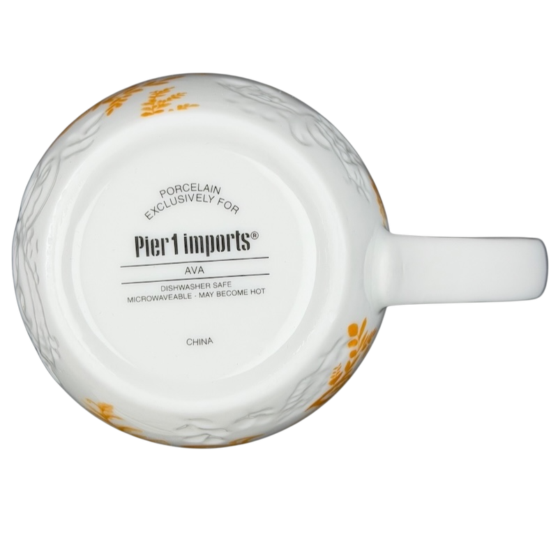 Bottom view of Pier 1 Imports monogram Ava mug K featuring elegant floral design and care instructions