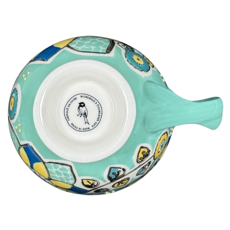 Top view of Anthropologie Elka Ayaka green floral pedestal mug showing turquoise handle and yellow blue floral pattern