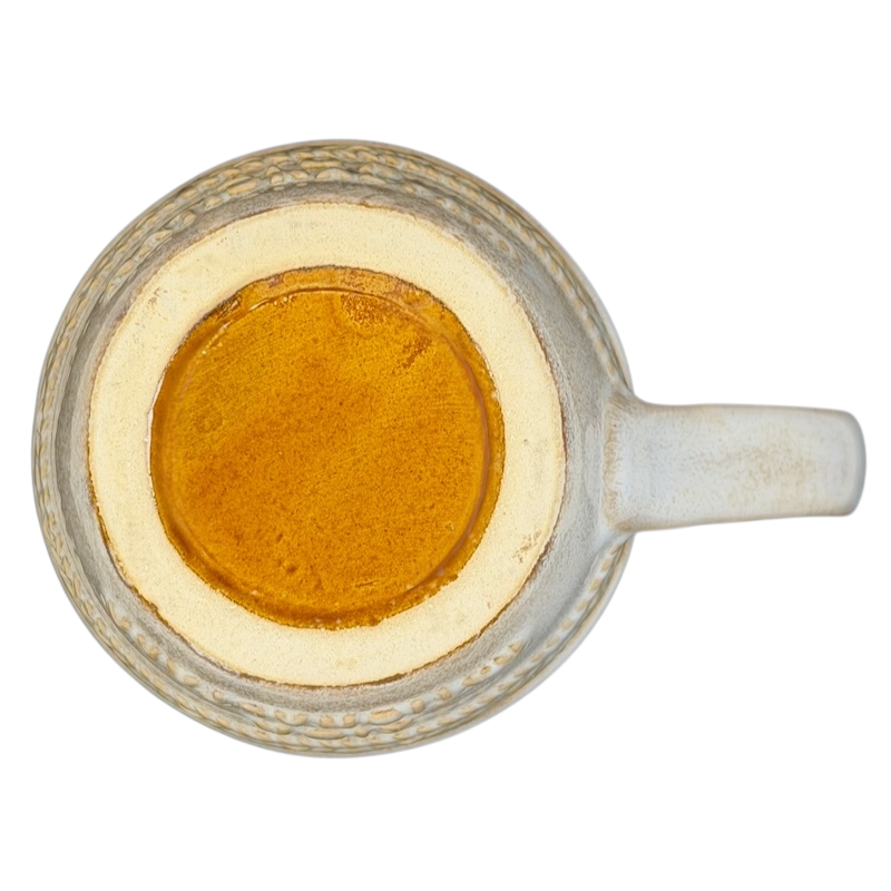 Top view of a rustic Zion National Park mug with a textured design and golden liquid inside