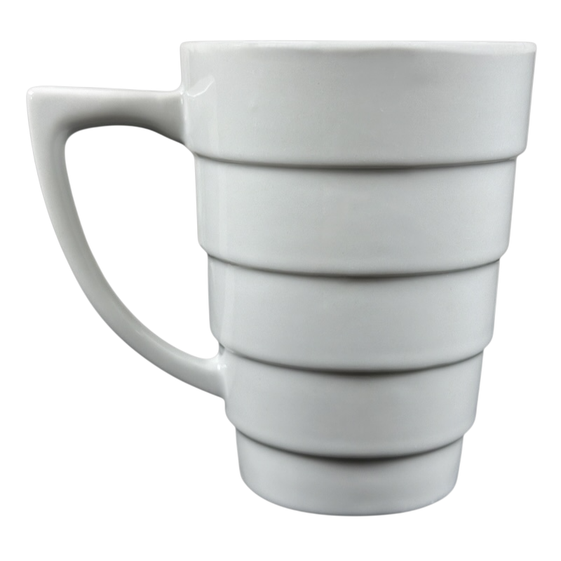 White ceramic Frank Lloyd Wright vintage Guggenheim mug with stepped spiral bands and ergonomic handle