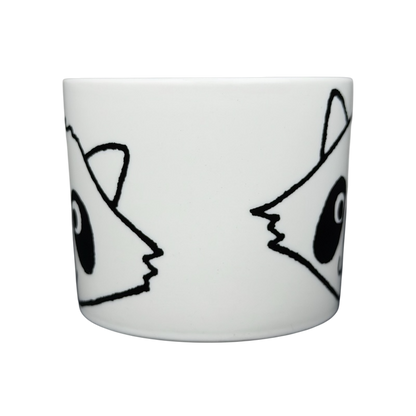 White ceramic Raccoon Mug Aiwa featuring playful raccoon face designs on both sides