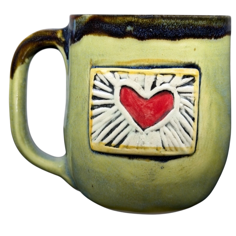 Alissa Clark Clayworks heart mug featuring a raised heart design on a vibrant yellow background