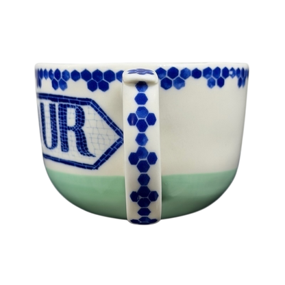 Bonjour Pottery Bistro Mug Anthropologie with a blue pattern and a handle on the side