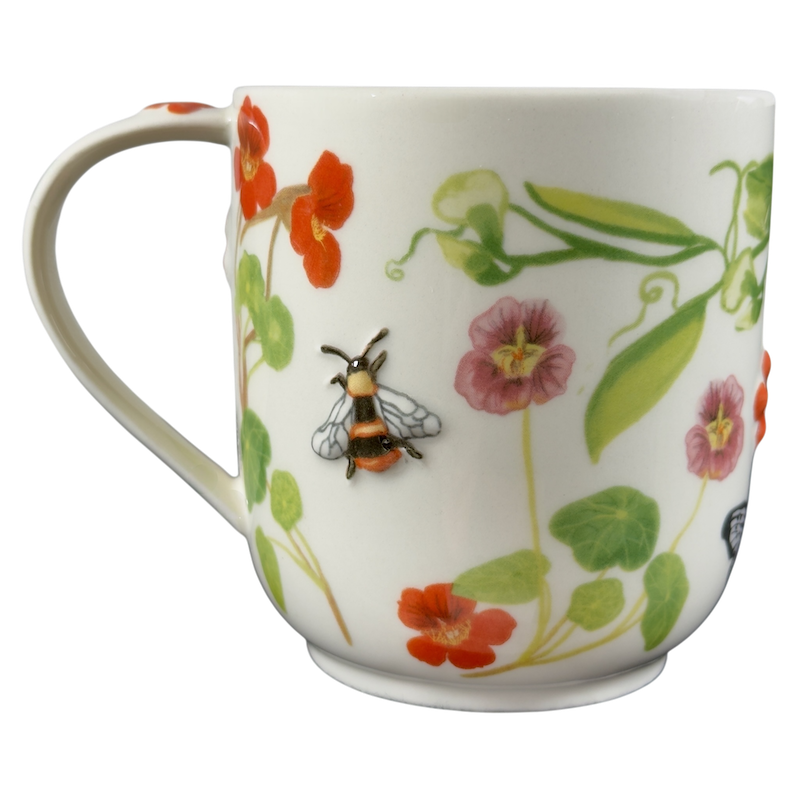Collectible monogram mug Anthropologie featuring vibrant floral designs and a detailed bee embellishment