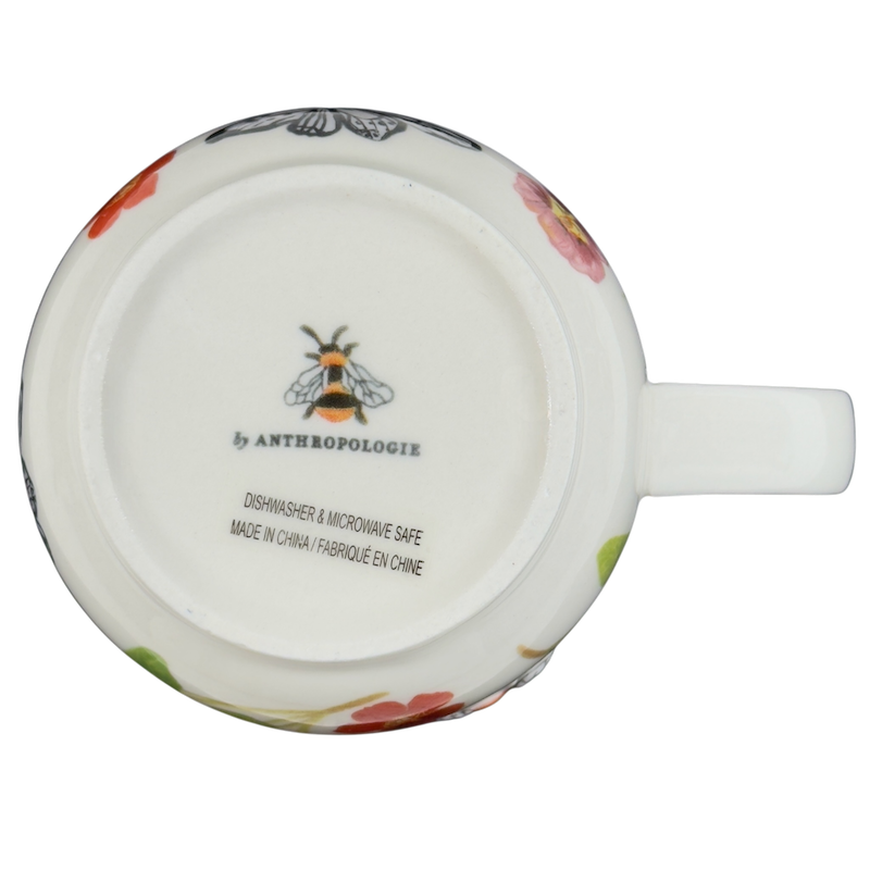 Bottom view of a collectible monogram mug Anthropologie featuring floral designs and a bee logo