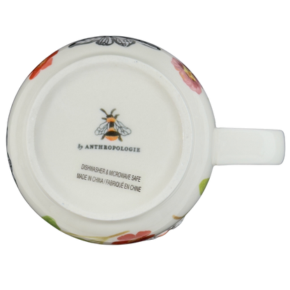 Bottom view of a collectible monogram mug Anthropologie featuring floral designs and a bee logo