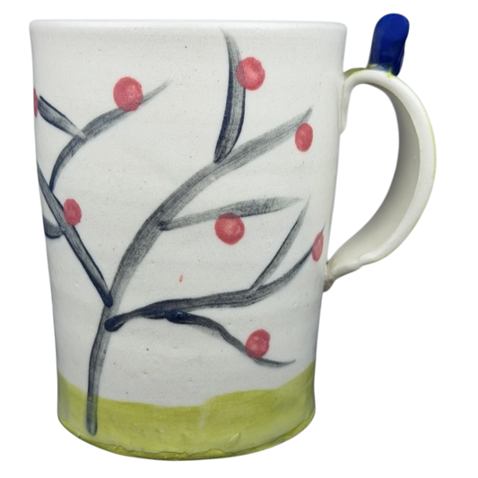 Handcrafted artisan pottery mug with bird topper and decorative floral design