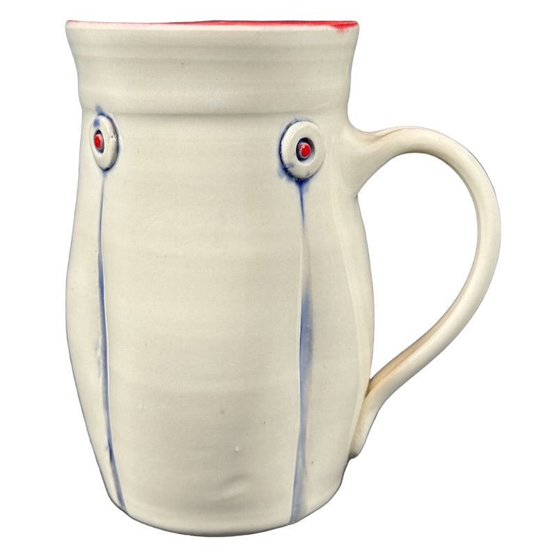 Handmade cream ceramic mug with red interior rim blue drip accents and round embossed buttons Rebecca Lowery embossed pottery mug