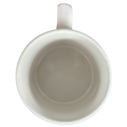 Top view of a white mug featuring Barbara Lavallee Inuit family sledding design for warm beverages