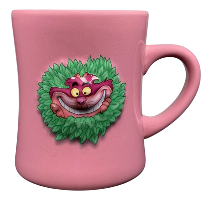 Alice In Wonderland Cheshire Cat Mug Disney in pink with a vibrant cat design on a leafy backdrop