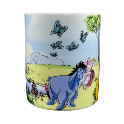 Disney collectible mug Eeyore Piglet featuring characters in a colorful outdoor scene with butterflies and greenery