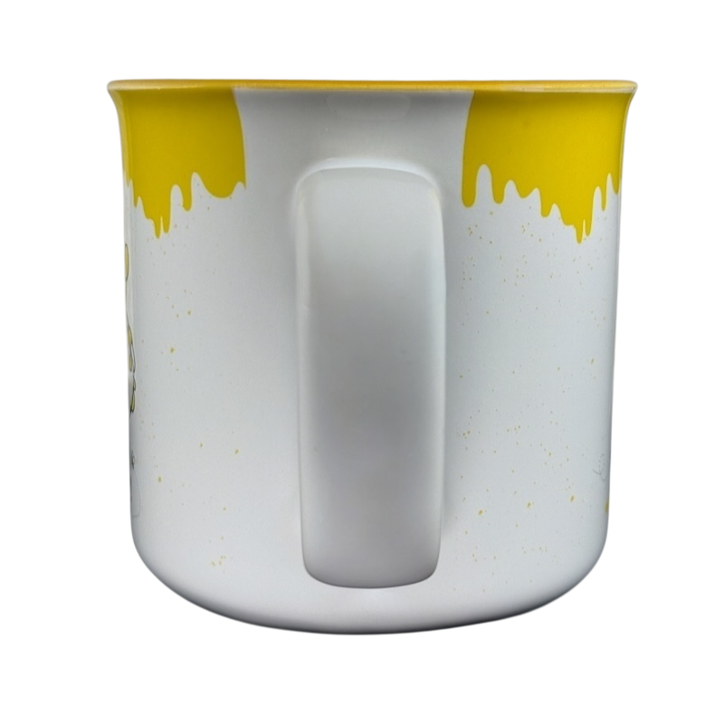 Disney collectible Winnie the Pooh mug with yellow dripping honey design and white handle