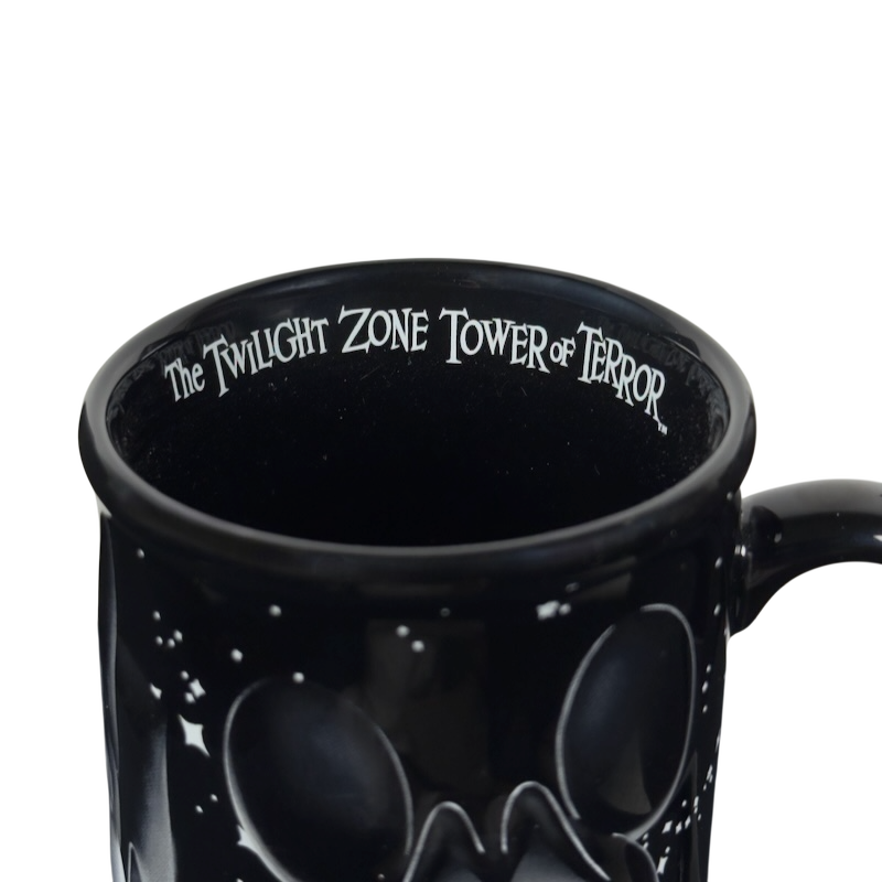 Close up black ceramic Twilight Zone Tower of Terror Disney collectible mug with inner rim lettering and starry design
