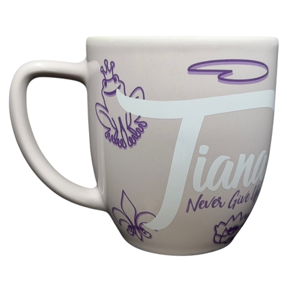 Princess Tiana Never Give Up Mug Disney Parks featuring a pastel design with Tiana and frog illustrations