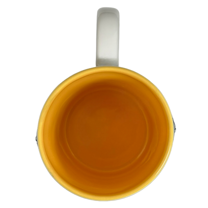 Top view of Winnie The Pooh Embossed Mug Disney with vibrant yellow interior and white handle