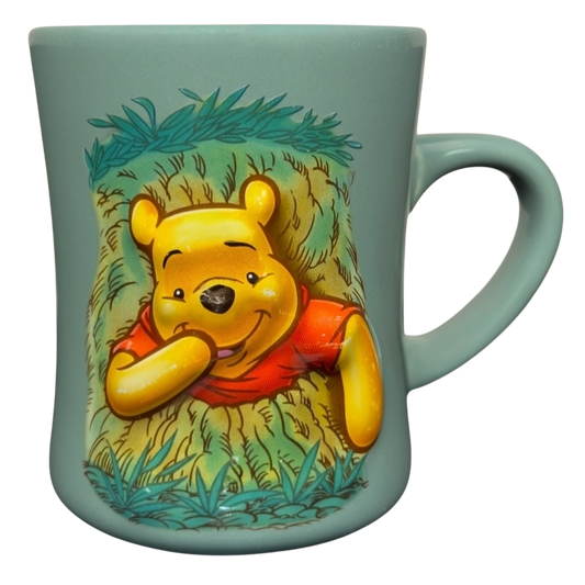 Disney ceramic mug featuring Winnie the Pooh stuck in tree vintage mug design on seafoam green background