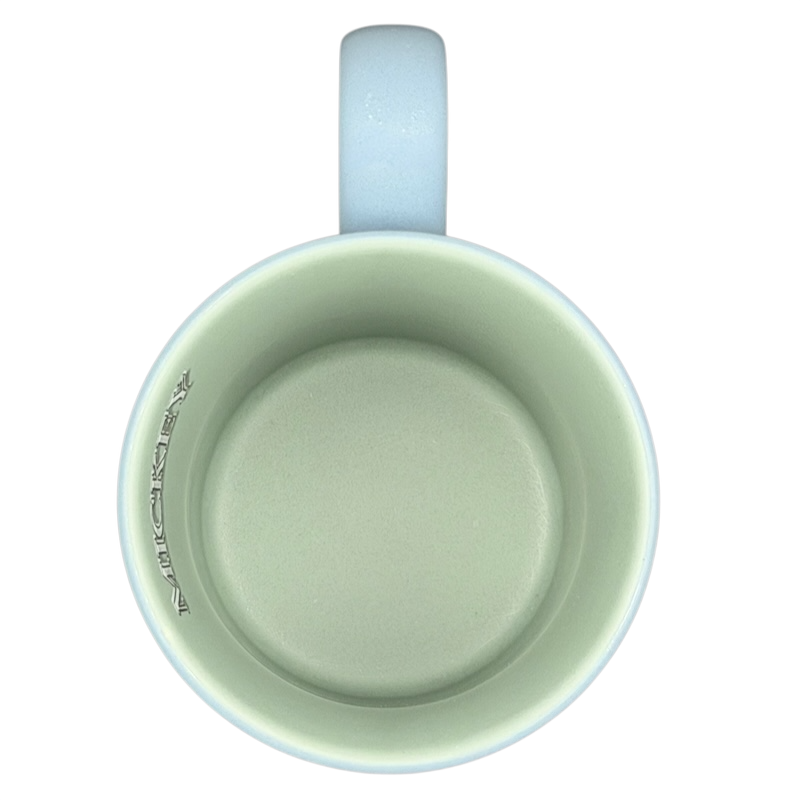 Inside view of a light green Mickey Mouse 5 Poses Disneyland Mug with a curved handle