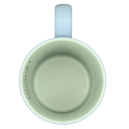 Inside view of a light green Mickey Mouse 5 Poses Disneyland Mug with a curved handle