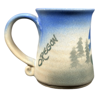 Dulcie Lindsoe-Johansen Mt. Hood pottery mug featuring a blue gradient and Oregon woodland design