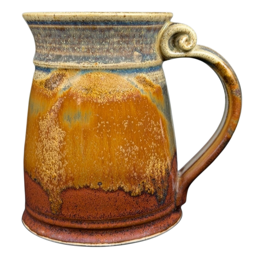 Earth-toned handcrafted pottery mug with a unique rustic design and a curved handle