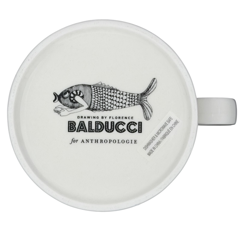 Florence Balducci Cat Monogram Initial Mug Anthropologie with a whimsical fish design on a white ceramic surface