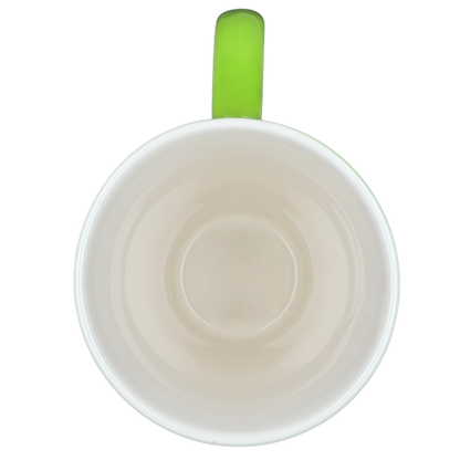 Top view of Hallmark Christmas Peace On Earth mug with a green handle and smooth interior