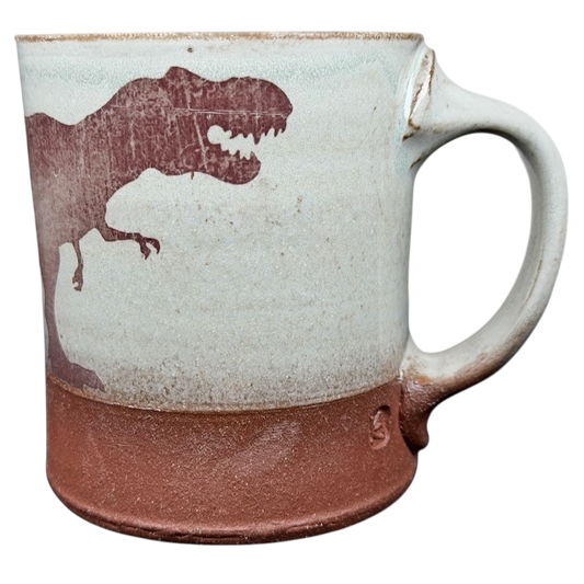 Handcrafted T-Rex pottery mug with a dinosaur design and earthy color palette