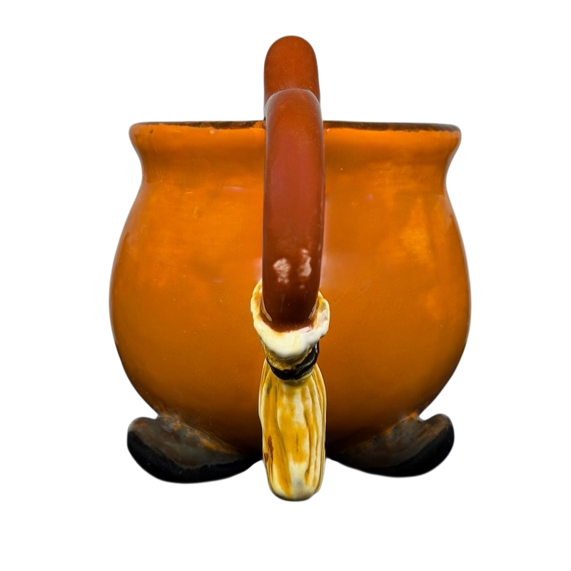 Handmade witch cauldron mug with a curved handle and decorative feet for unique drinkware