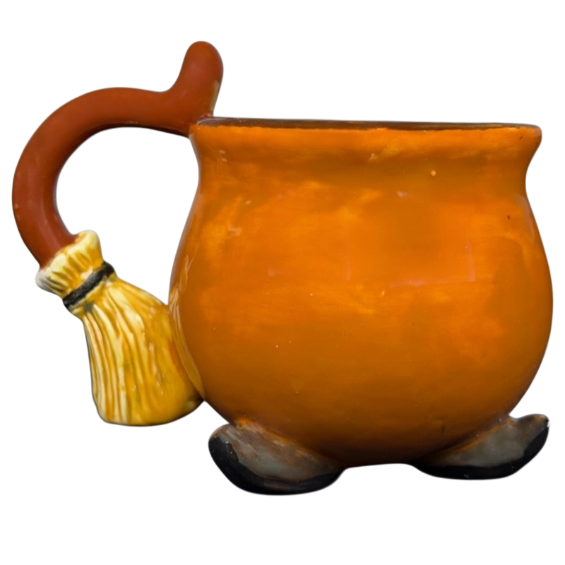 Handmade witch cauldron mug in orange with broomstick handle for whimsical drinkware