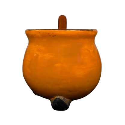 Handmade witch cauldron mug in orange ceramic with a sturdy handle and round base