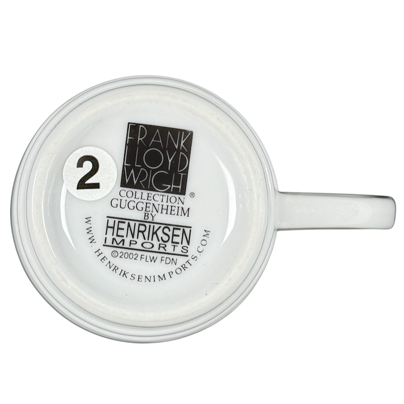 Bottom view of white Frank Lloyd Wright vintage Guggenheim mug showing Henriksen Imports stamp and number sticker