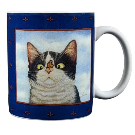 Hugo Hege cat Lang & Wise mug featuring a cat with a butterfly on its nose against a blue background