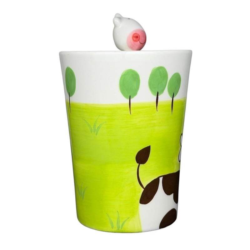 Indra vintage cow handle mug with playful cow design and colorful green field detail
