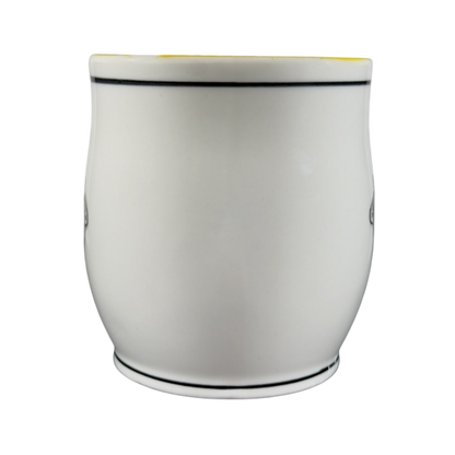 White ceramic Katie Mandy collectible mug with black trim on top and bottom edges