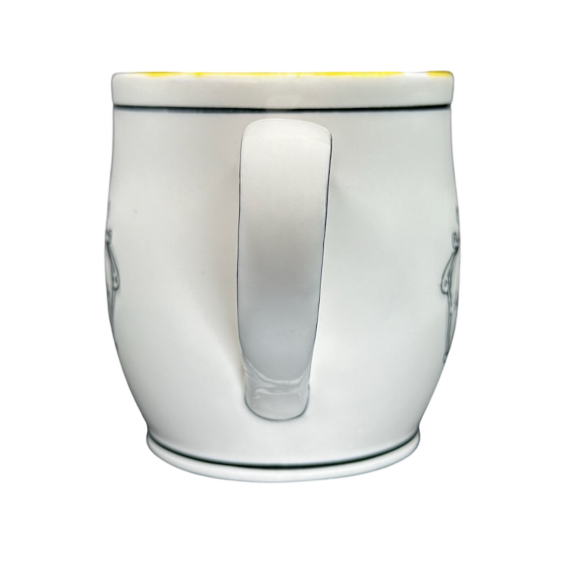 White ceramic Katie Mandy collectible mug with a curved handle and black rim detail