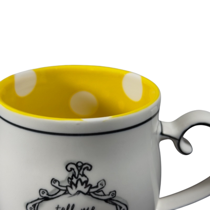 Katie Mandy collectible mug with yellow polka dot interior and decorative black design on white exterior