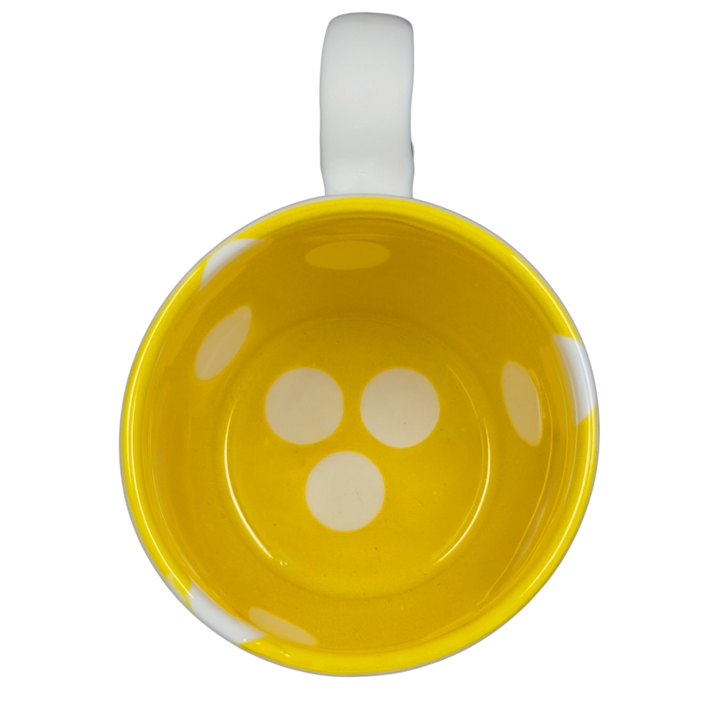 Top view of a yellow Katie Mandy collectible mug with white handle and polka dot design inside
