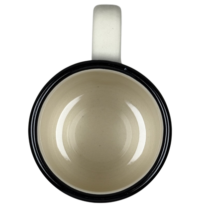 Top view of empty ceramic mug with cream interior black rim and white handle Karen Donleavy Bichon Frise mug