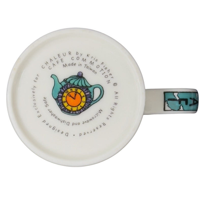 Bottom view of Decaf Kris Fisher Chaleur mug showing colorful teapot illustration, maker text and turquoise handle on ceramic