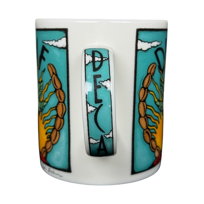 Decaf Kris Fisher Chaleur mug white ceramic with turquoise panels sun and wheat design and cloudy handle