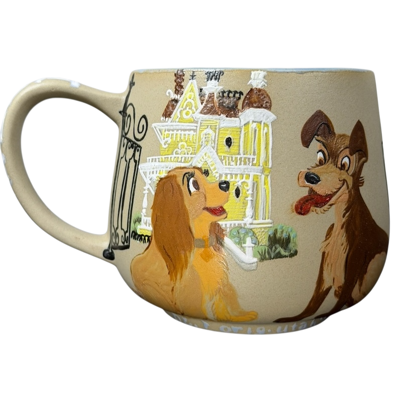 Lady and the Tramp hand-painted pottery mug featuring vibrant dog characters against a colorful backdrop