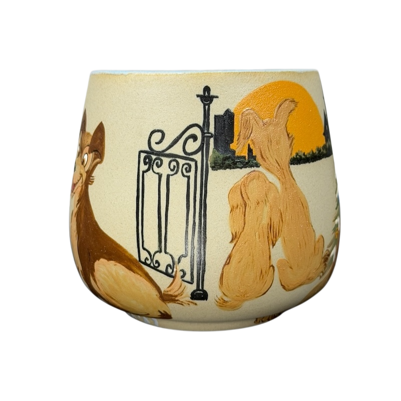 Lady and the Tramp hand-painted pottery mug featuring a sunset scene with the two dogs