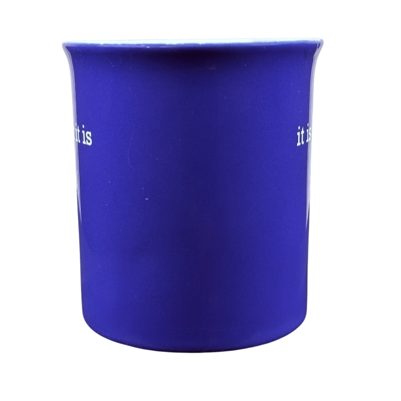 Matte cobalt blue ceramic mug with minimalist white text it is what it is Love Your Mug. front view on black background