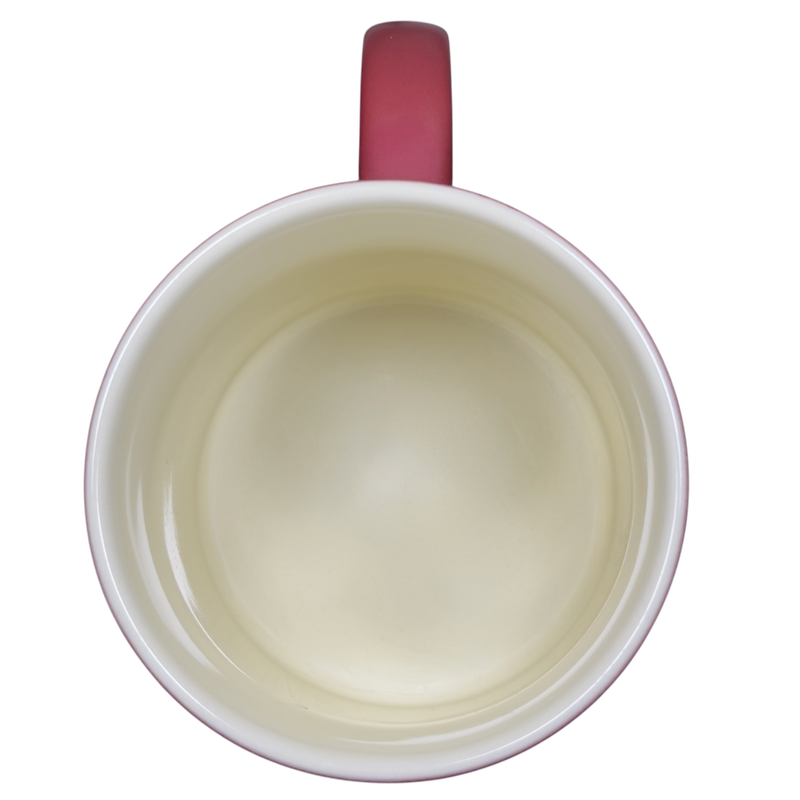 Inside view of a Mickey Mouse vintage smile mug with a cream interior and red handle
