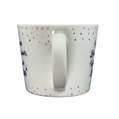 Cooksmart When It Rains Look For Rainbows mug white ceramic with handle center multicolored star pattern and navy script on black