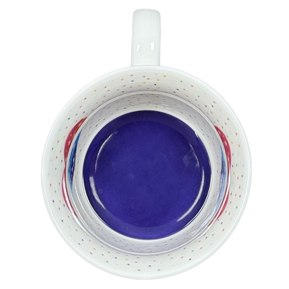 Top view of Cooksmart When It Rains Look For Rainbows mug. White speckled interior with cobalt blue base and rainbow accents