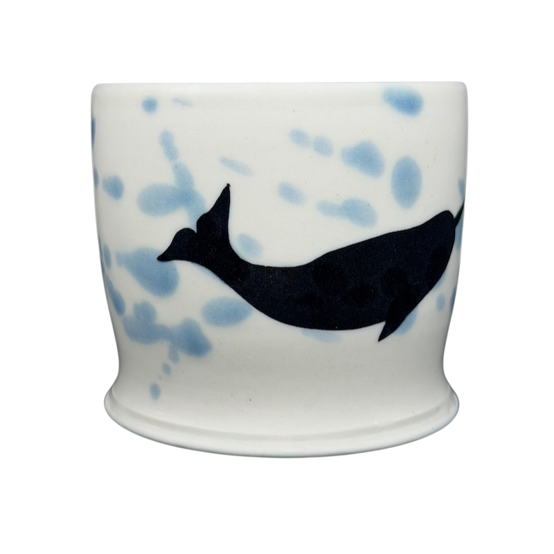 Artistic narwhal signed pottery mug featuring a blue and black design on a white background