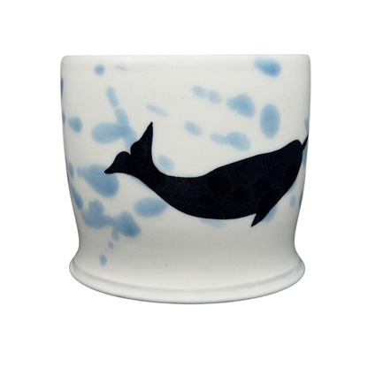 Artistic narwhal signed pottery mug featuring a blue and black design on a white background
